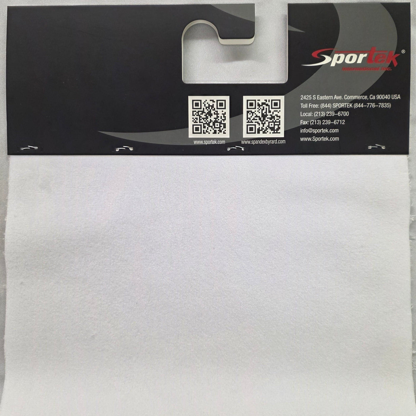 A white rectangular foam or felt pad attached to a black hanging retail card with the Sportek logo, photographed flat against a light fabric background.