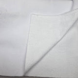 A close-up of a folded white terry cloth towel or blanket, showing the soft textured fabric on both sides against a neutral light gray background.